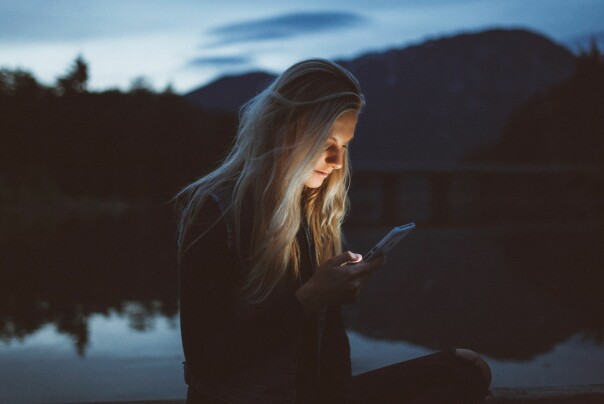 En kvinne flikker litt på mobilen sin. 📷: Becca Tapert / Unsplash