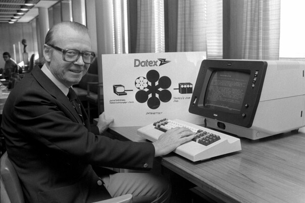 'Generaldirektør Kjell Holler åpner Televerkets nye teletjeneste DATEX som er etablert for å tilfredsstille det stadig økende krav til sikker og økonomisk dataoverføring. Kjell Holler ved datamaskin med Televerkets logo og Datex på plakat i bakgrunnen.' 📸: NTB Scanpix