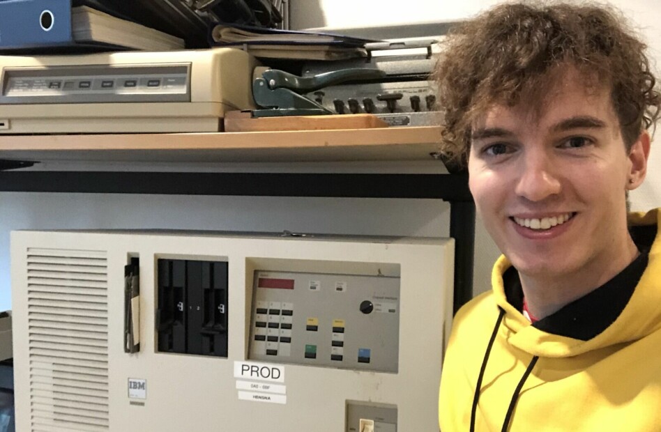 Utvikler Eirik Sletteberg i NAV poserer foran hardware som ble brukt til å kjøre Det Sentral Folketrygdsystemet i produksjon. Bildet er tatt på NAV sitt teknologi-museum. 📸: Privat