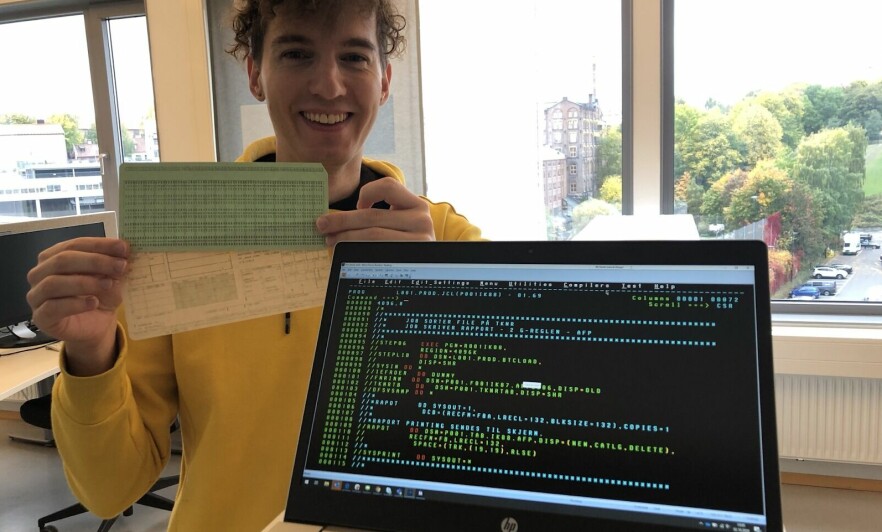 Utvikler Eirik Sletteberg i NAV poserer foran kode som ble brukt til å kjøre Det Sentral Folketrygdsystemet i produksjon. 📸: Privat