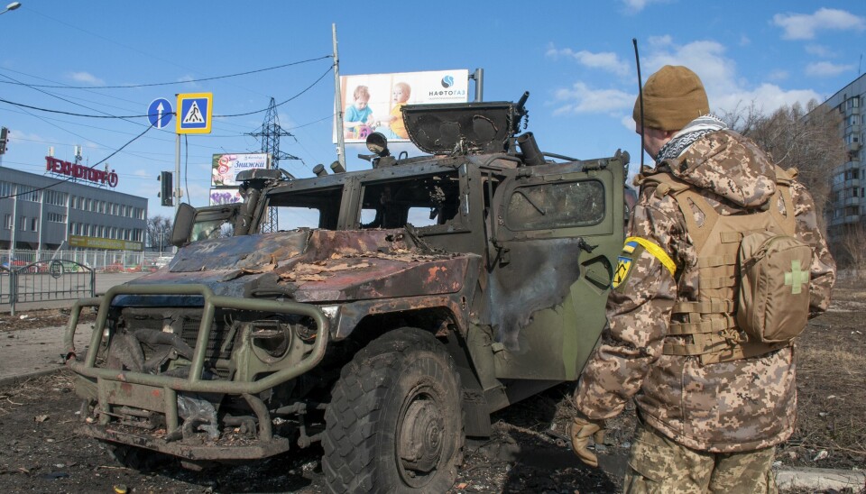 En ukrainsk soldat inspiserer en ødelagt millitærbil etter kamper i Kharkiv, Ukraina. 📸: AP Photo / Marienko Andrew / NTB