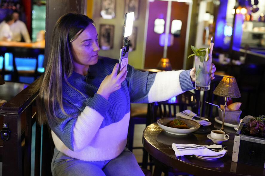 Innholdsskaper Jensen Savannah lager en video for en klient på restauranten El Puro i Charlotte, North Carolina. 📸: Erik Verduzco / AP / NTB
