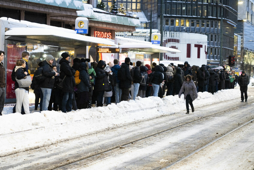 I Oslo sentrum er det trøbbel med kollektivtrafikken. Her står svært mange mennesker i kø på en snøfylt holdeplass for å komme seg med en trikk fra Jernbanetorget denne uka. 📸: Erik Flaaris Johansen / NTB