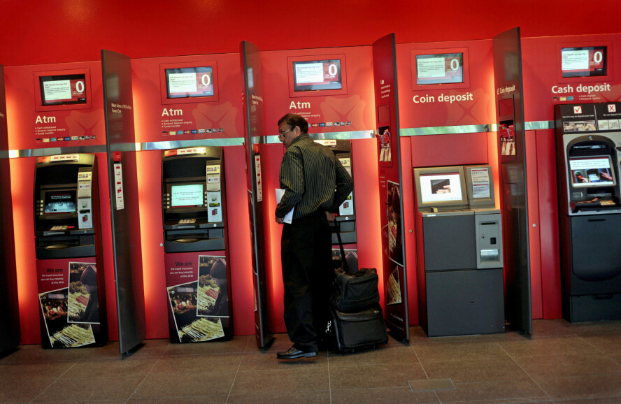 En mann bruker automatene til DBS Bank i Singapore. Banken varsler at de vil nedbemanne med flere tusen og heller satse på AI. 📸: Wong Maye-E / AP / NTB