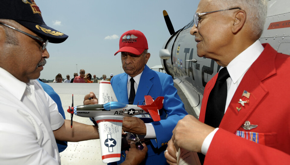 Veteraner fra den fargede flyskvadronen Tuskegee Airmen møttes i 2012 for å signere en modell av flyene de førte. De er nå skrevet ut av det amerikanske Forsvarsdepartementets historie. 📸: Todd McInturf / AP / NTB