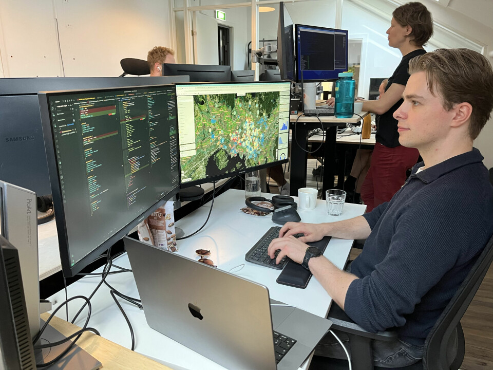 Erling Olweus er utvikler i Atlas. Utvikleren Erling Olweus på kontorplassen, koder på en Mac med to skjermer.