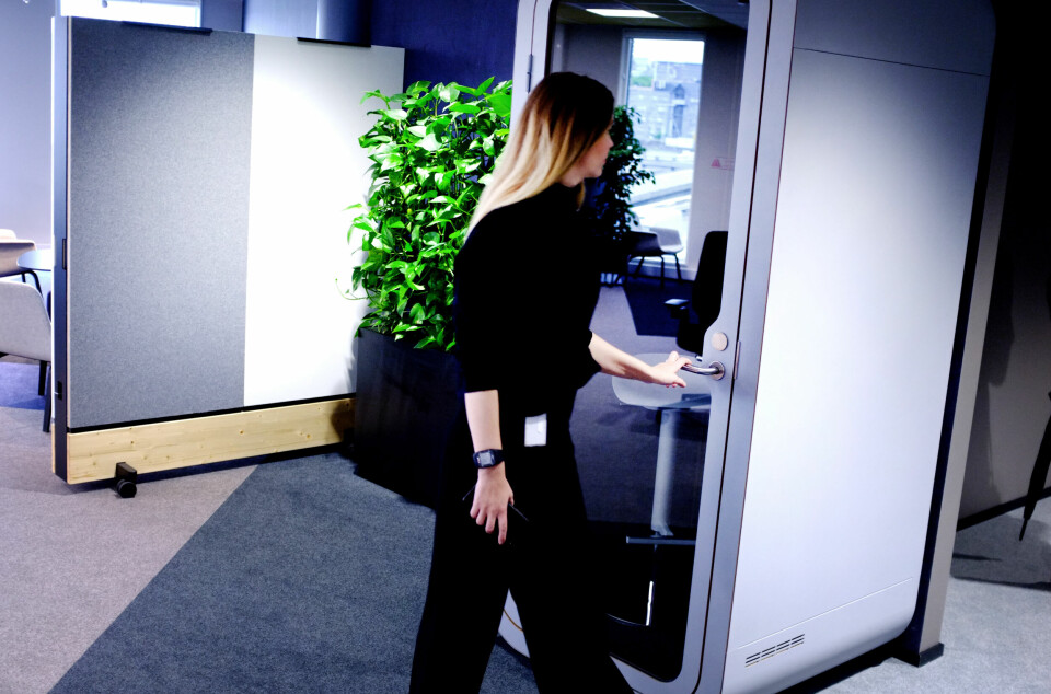 Det er uklart hvordan ukas nedbemanning hos Microsoft vil slå ut i Norge. Selskapet har heller ingen informasjon å dele om hva nedbemanningen i mai har ført til for norske Microsoft-ansatte. Her fra kontorene i Bjørvika i Oslo. Bildet er av en kvinne som tar tak i dørhåndtaket på en stillebås, utforma som en høy kube med en glassdør og ellers tette, lydisolerte vegger.