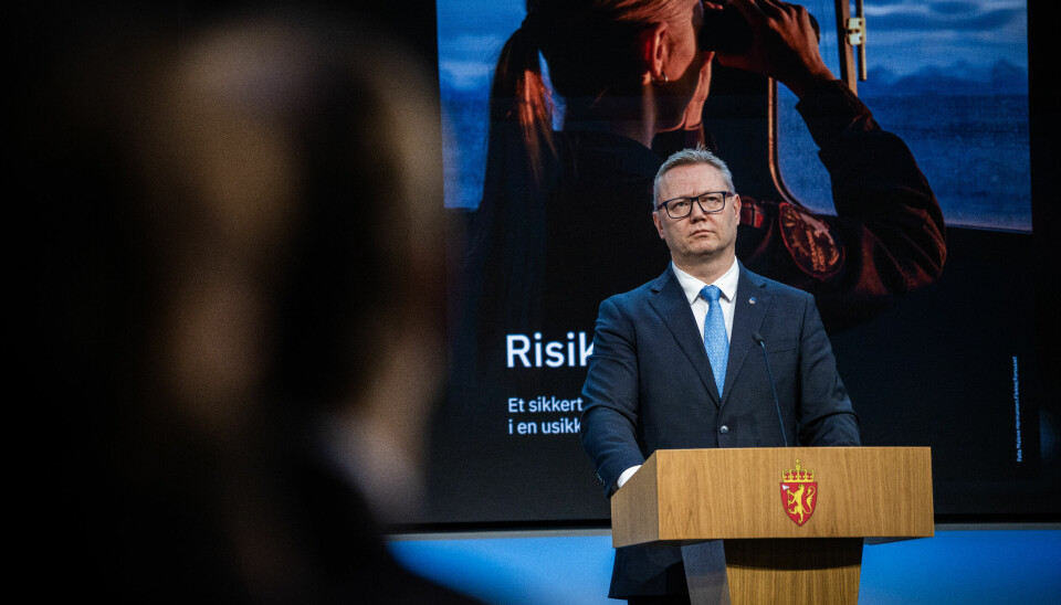 NSM-sjef Arne Christian Haugstøyl advarer mot risikoen av å gjøre seg for avhengig av teknologi fra et spesifikt land. Bildet er av en mann i dress, som står på en talerstol, foran en stor skjerm.