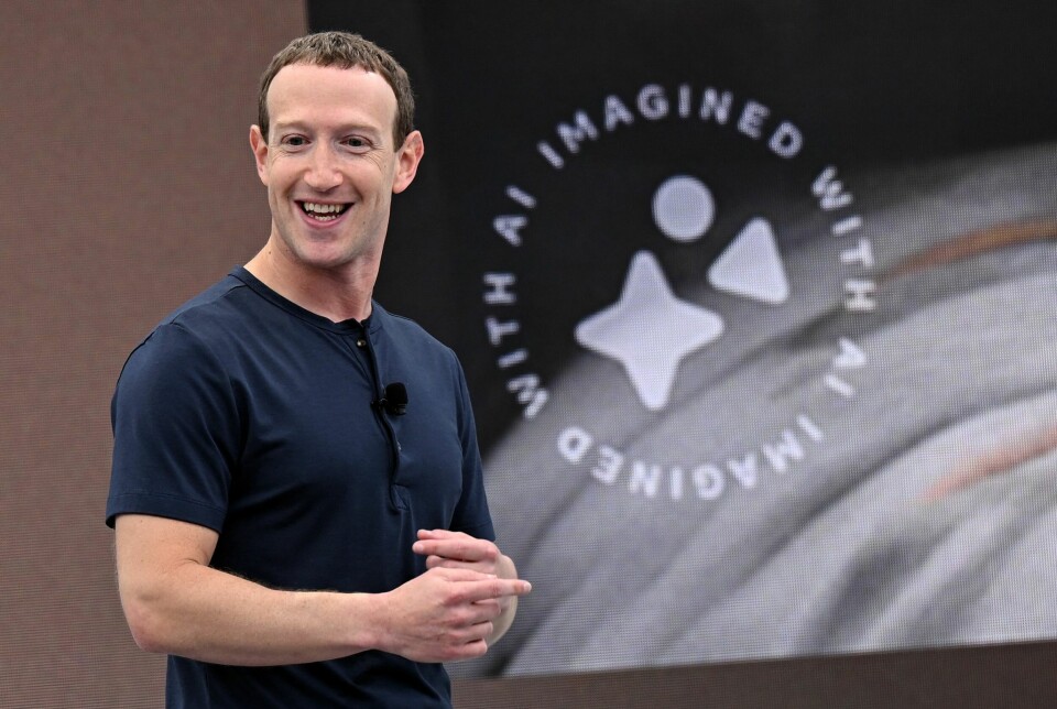 Mark Zuckerberg og Facebook har sletta rundt 10 millioner kontoer i løpet av årets seks første måneder. Bildet er av en mann i mørkeblå t-skjorte som står på en scene. Han holder hendene samla, og smiler.