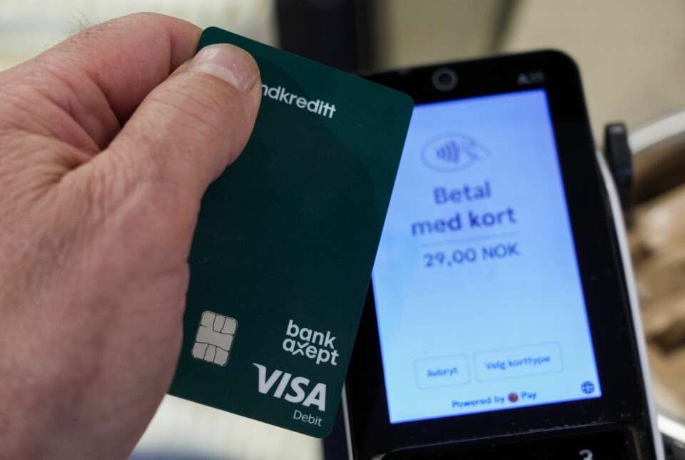 Den norske betalingsløsningen Bankaxept gjør at dette kortet skal fungere i én i uke, om en uventet situasjon skulle oppstå. Bildet viser en bankterminal og ei hånd med et bankkort, som har logoen til Bankaxept og Visa.