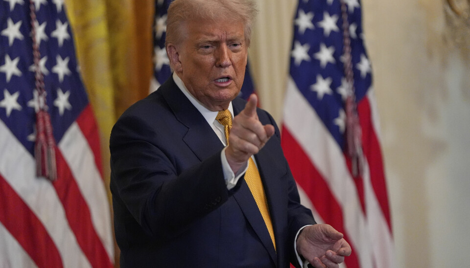 USAs president Donald Trump lanserte onsdag en ny AI-strategi. Bildet er av en eldre mann i dress som peker mot kamera, og i bakgrunnen henger det amerikanske flagg. Det er Donald Trump.