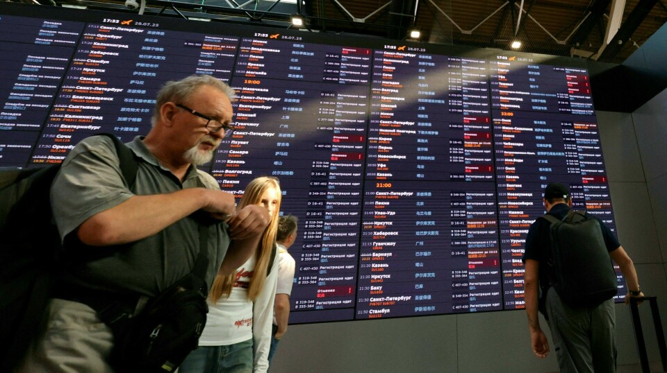 Mange russere ble stranda på flyplasser etter et hackerangrep mandag. Ifølge gruppene som har tatt på seg ansvaret skal det ha vært muliggjort av gammel tech og gamle passord. Bildet er av en avgangstavle på en russisk flyplass, med mennesker som går foran. Mange av avgangene er avlyst eller forsinka.